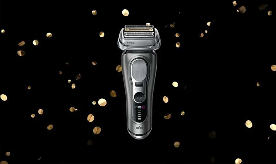 Op de afbeelding zie je een moderne, zilverkleurige Braun scheerapparaat tegen een zwarte achtergrond met gouden confetti.