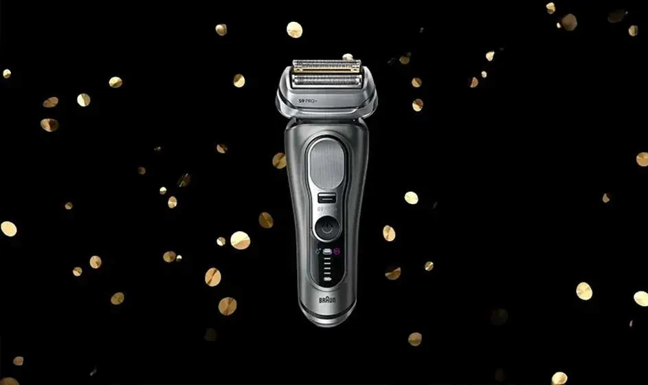 Op de afbeelding zie je een moderne, zilverkleurige Braun scheerapparaat tegen een zwarte achtergrond met gouden confetti.