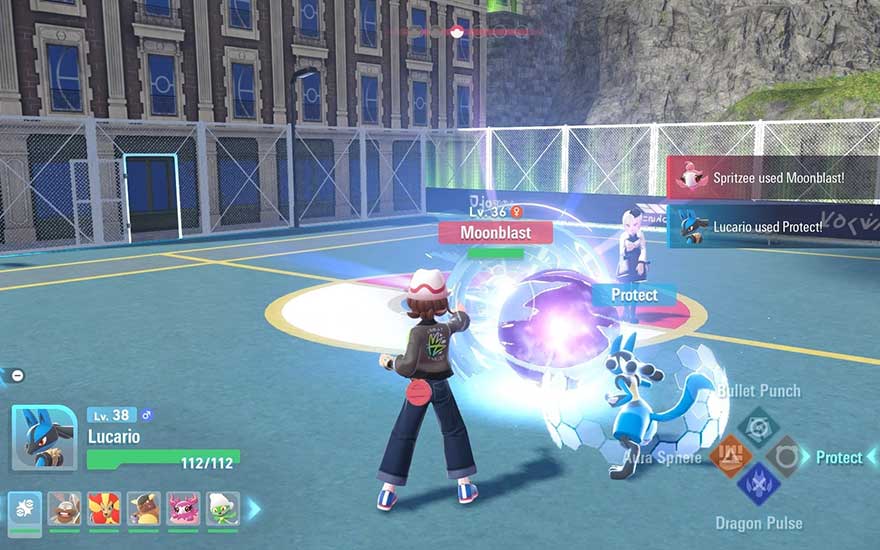 Un dresseur ordonne à Lucario de se protéger contre Moonblast lors d’un combat Pokémon sur une cour d’école.