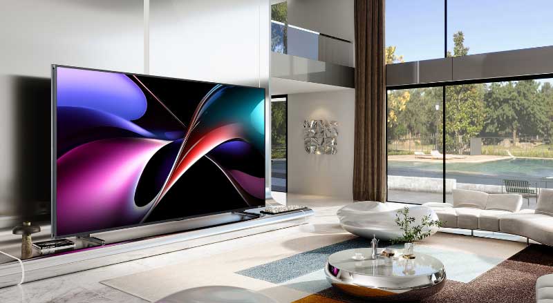 Un immense téléviseur à écran plat affiche des visuels abstraits colorés dans un salon lumineux au style luxueux.
