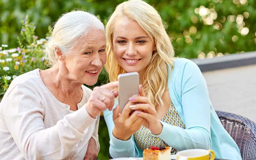 Deux femmes partagent un moment autour d’un téléphone.