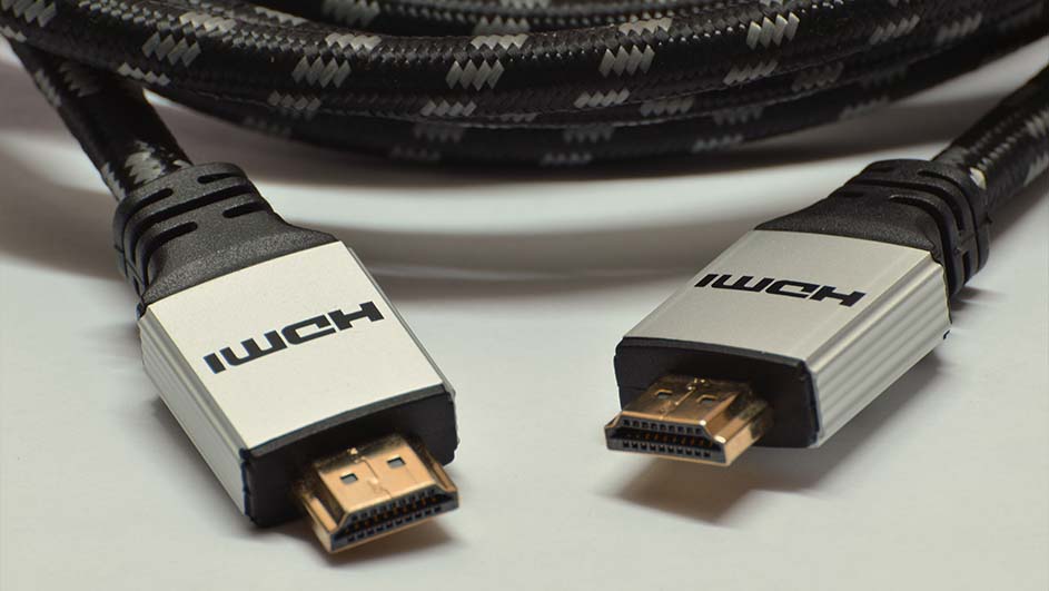 Deux câbles HDMI avec des connecteurs dorés reposent sur une surface claire, avec un câble tressé noir et gris.