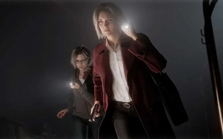 This is a video game. Two women search a dark room; one in a red coat raises a flashlight while the other, wearing glasses, follows closely.