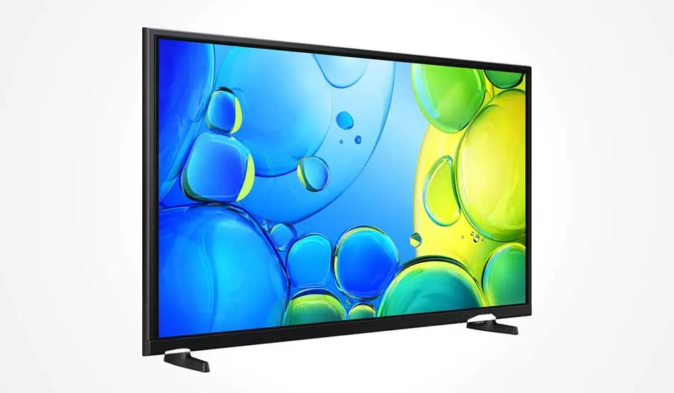 Une télévision à cadre noir fin posée sur deux pieds larges affiche un motif abstrait de bulles bleues et jaunes à l’écran.