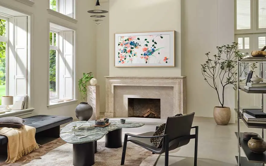 Un salon élégant et lumineux avec de grandes fenêtres, du mobilier moderne et un tableau abstrait au-dessus de la cheminée.