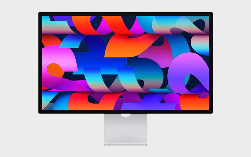 Een Apple Studio Display met zwarte rand en zilveren voet toont een levendige compositie van overlappende, kleurrijke geometrische vormen op het scherm.