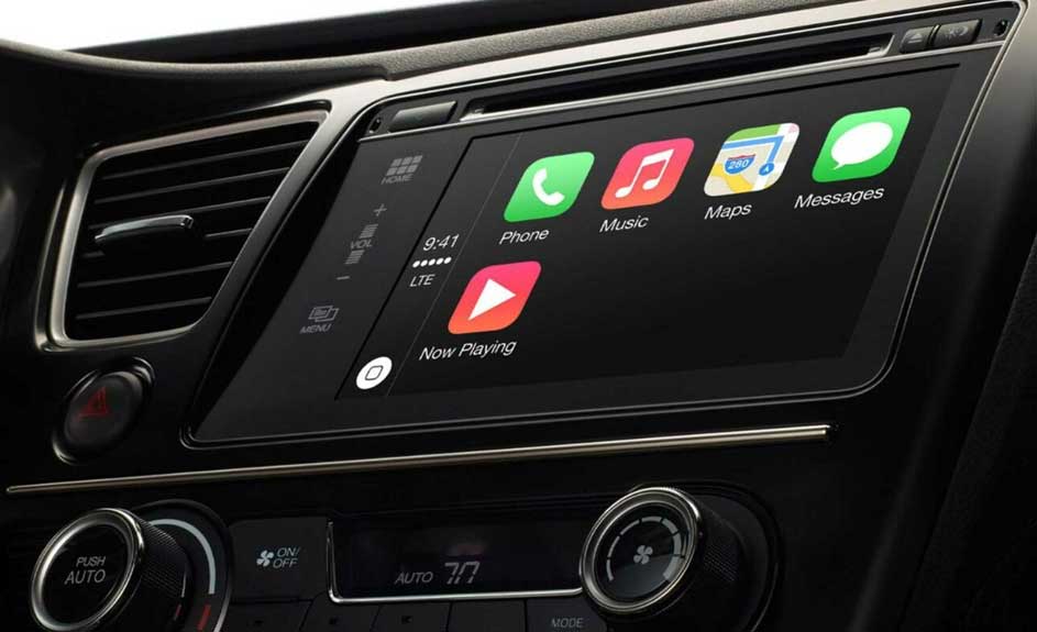 Tableau de bord noir avec écran tactile affichant les icônes Téléphone, Musique, Cartes et Messages, ainsi que les commandes de climatisation.
