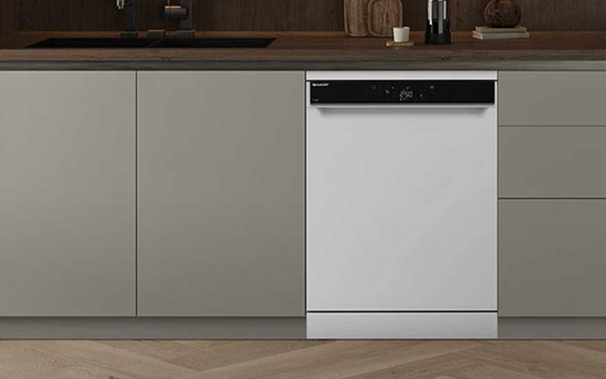 A white freestanding dishwasher is seamlessly built into light kitchen cabinets, featuring a wooden countertop and minimalist style.