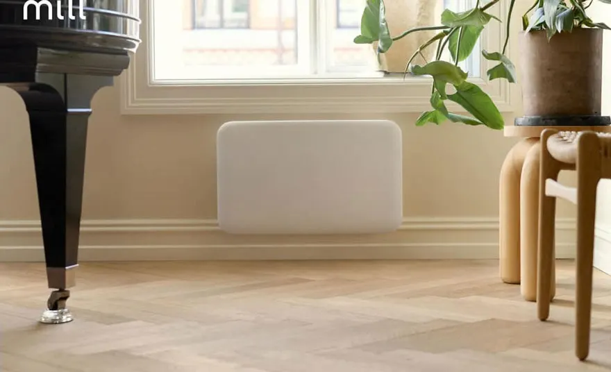 Woonkamer met een witte verwarming onder een raam, naast een piano en een houten kruk met een plant erop.