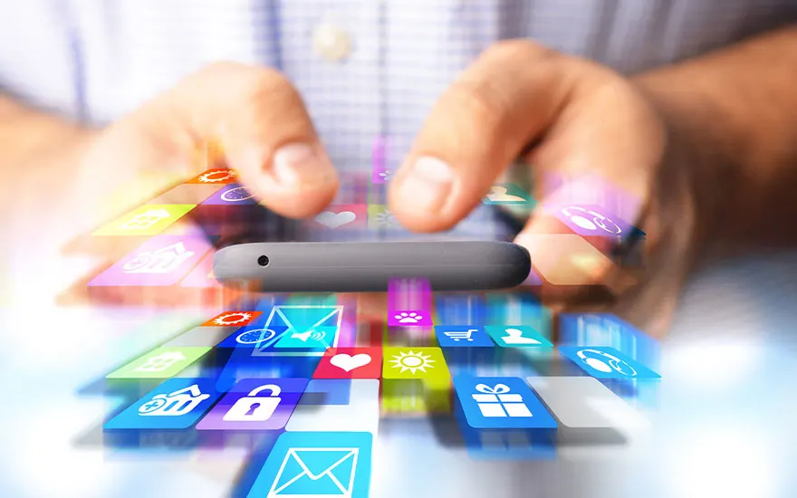 Les mains tapent sur un téléphone, entouré d'icônes d'applications colorées, sur fond de chemise claire.