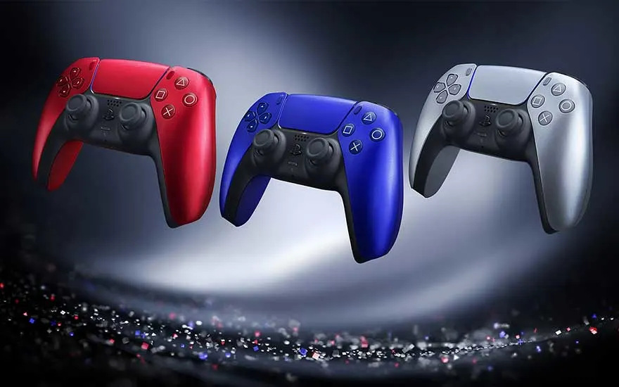 Trois manettes de jeu, rouge, bleue et argentée, flottent au-dessus d'un fond sombre avec des points lumineux.