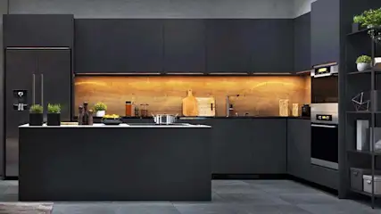 Een donkere keuken met een eiland, kasten, een koelkast en een rek met planten, alles in een grijze kleurenpalet.