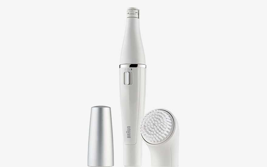Un appareil de beauté électrique, fin et élégant, avec brosse et capuchon, est présenté sur un fond blanc épuré.