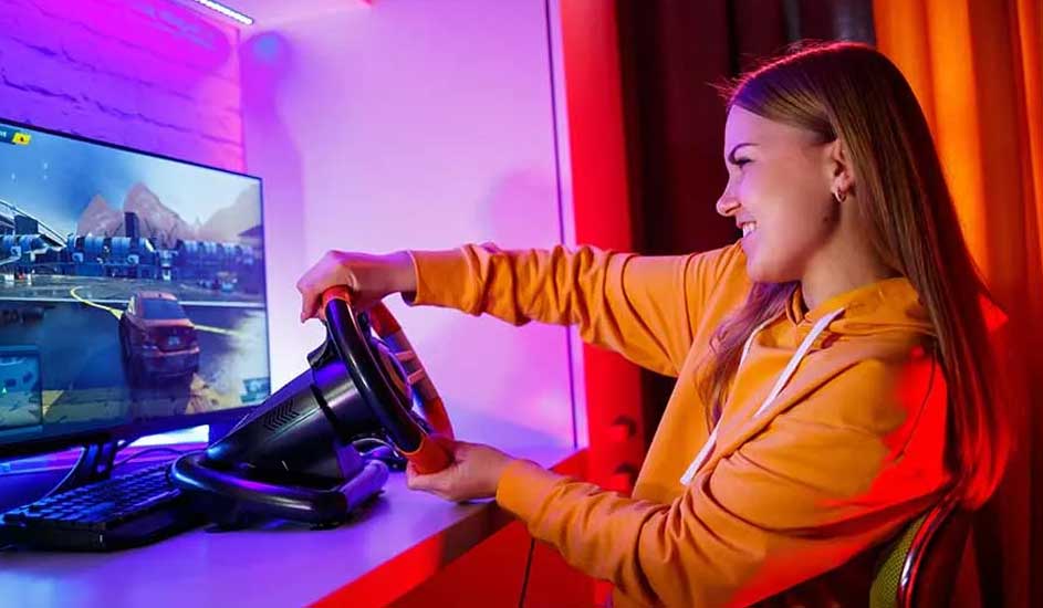 Een computerscherm toont een racegame, een stuurwiel en een toetsenbord staan op een bureau. De achtergrond heeft rode gordijnen.