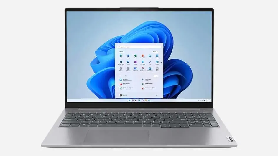 Ordinateur portable Lenovo argenté avec écran d'accueil Windows, affichant un fond bleu avec diverses icônes d'applications visibles.