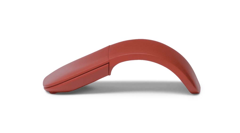 Une souris d'ordinateur rouge-brun est sur une surface blanche, vue de côté avec une forme arquée distinctive.