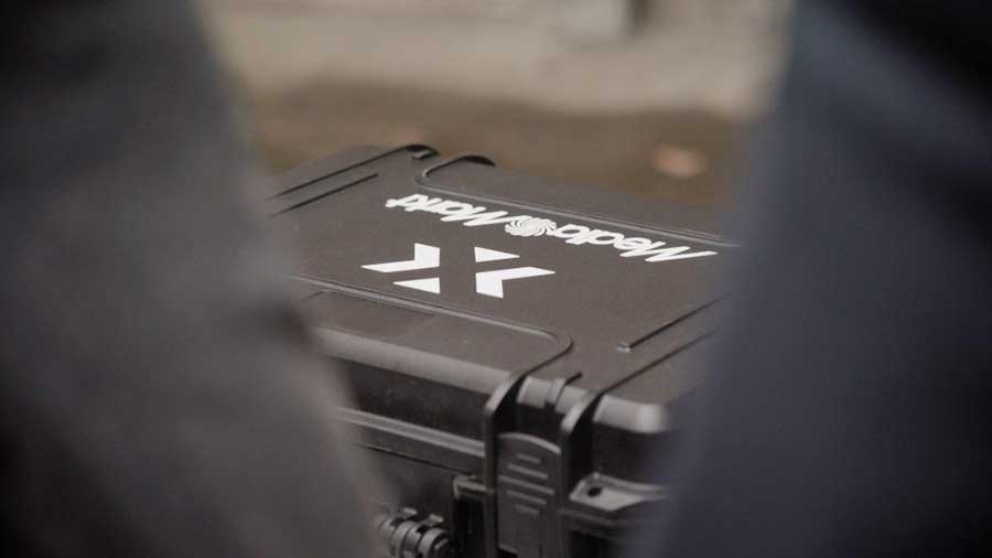 Gros plan d'une mallette noire avec logo blanc "MediaMatts", sur fond flou.