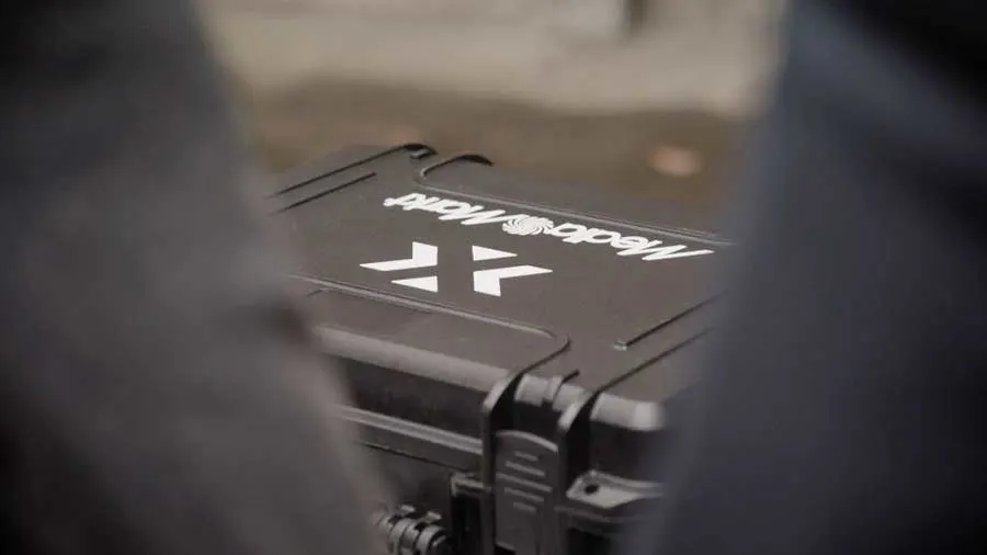 Gros plan d'une mallette noire avec logo blanc "MediaMatts", sur fond flou.