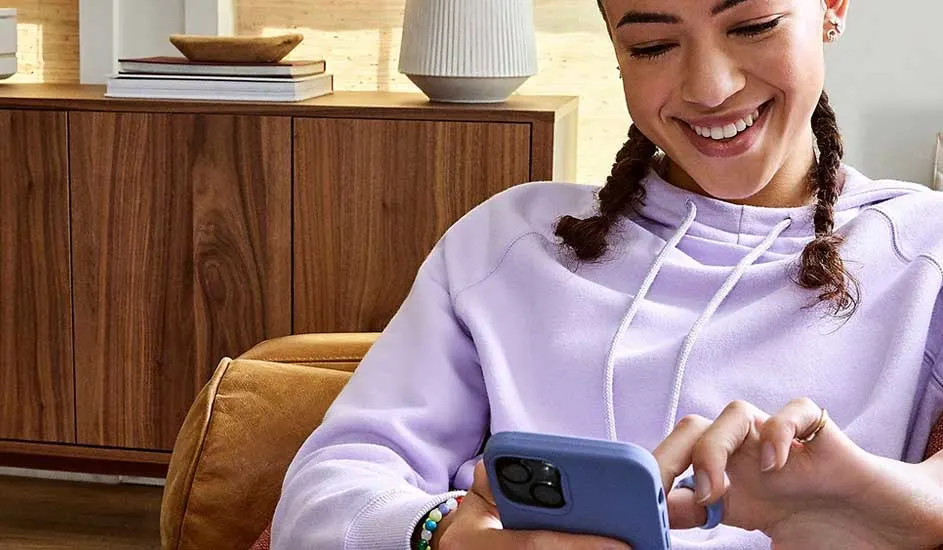 Een blauwe telefoon wordt gebruikt in een interieur met een houten kast en decoratieve elementen.