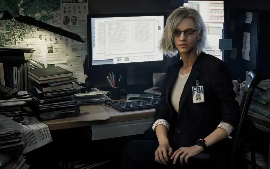 C'est un jeu vidéo. Une femme à lunettes avec badge FBI est assise dans un bureau encombré de dossiers; écran lumineux derrière, cartes au mur.