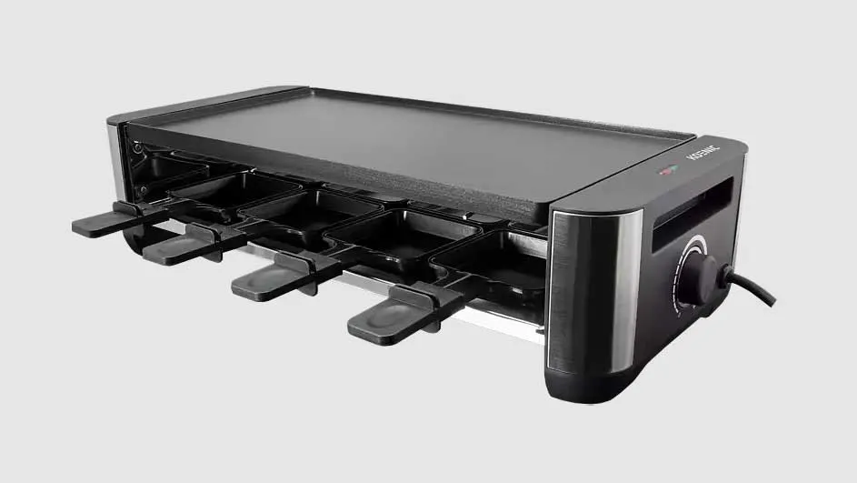 Zwarte raclette grill met vier pannen en een platte grillplaat, tegen een effen achtergrond.