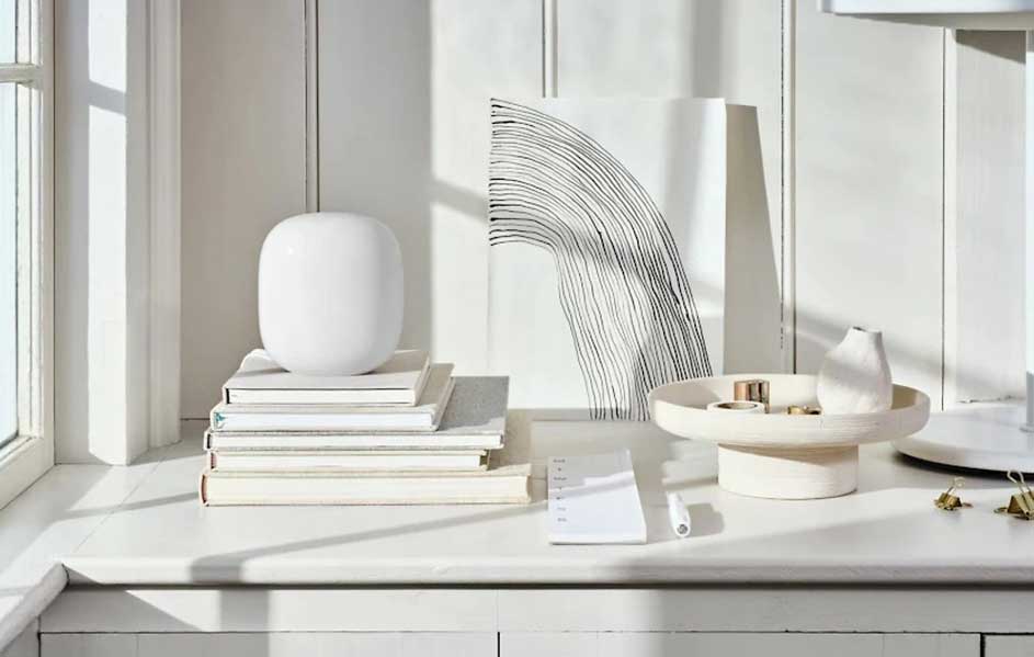 Een witte tafel met boeken, een vaas, een schilderij met lijnen en een schaal met decoratieve items.