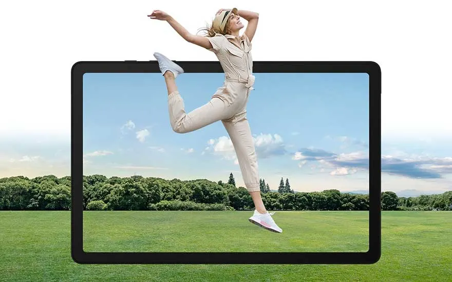 Une tablette noire affiche un paysage : ciel bleu, prairie verte et arbres. Une forme saute au-dessus, en tenue beige et baskets blanches.