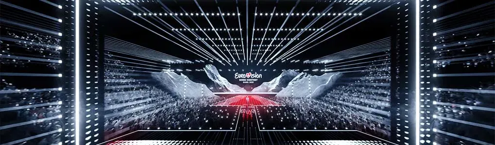Groot podium van het Eurovisiesongfestival met lichtlijnen en publiek.