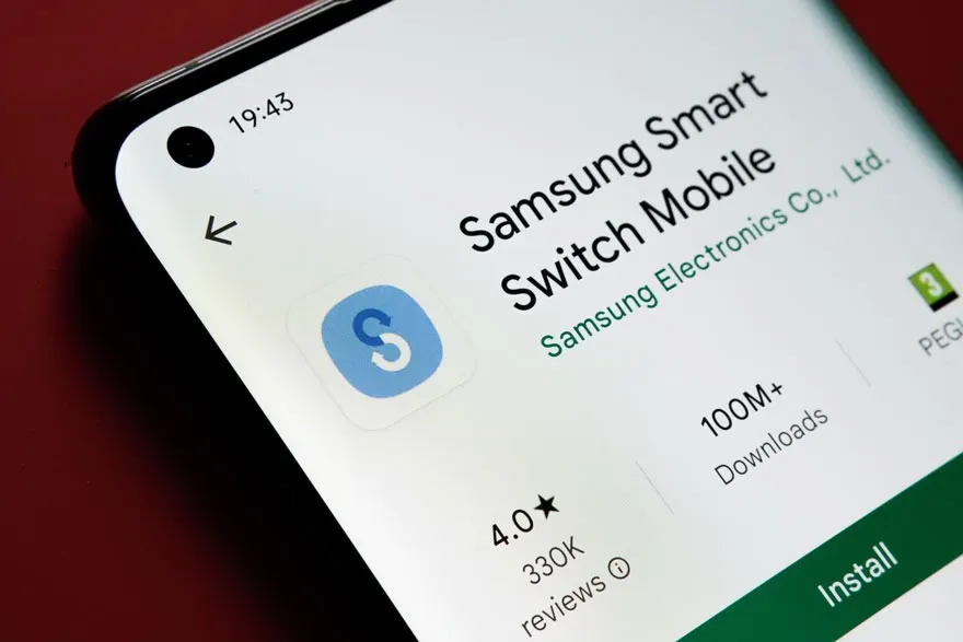 Een telefoon toont de Samsung Smart Switch Mobile app in de Google Play Store, met een blauw app-icoon en een groene installatieknop.