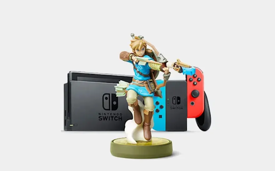 Une Nintendo Switch avec Joy-Con rouge et bleu et une figurine amiibo Link de The Legend of Zelda sont exposées ensemble.