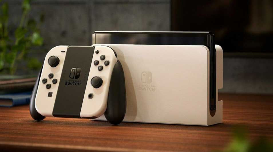 Console Nintendo Switch blanche et noire avec station d'accueil sur une table en bois.