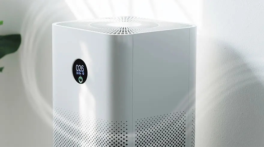 Een witte luchtreiniger met een zwart display dat "026" toont, staat tegen een witte achtergrond.