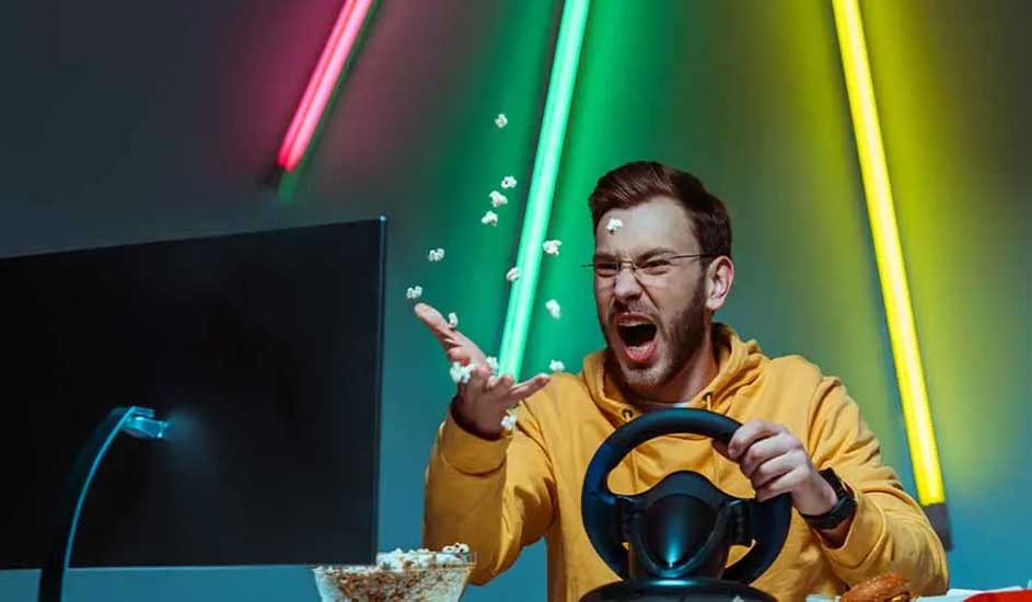 Un écran noir, un volant et du pop-corn sont visibles. Des néons roses, verts et jaunes illuminent le fond.