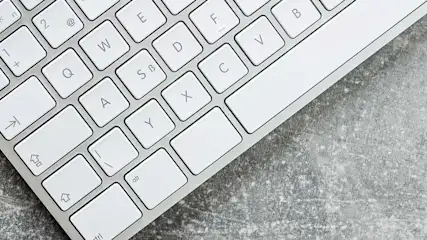 Witte toetsenbordtoetsen met letters op grijze achtergrond.