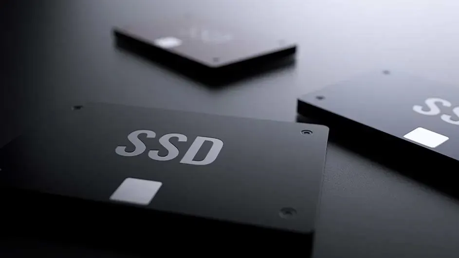 Trois disques SSD noirs sur une surface sombre. Le premier disque affiche en grand "SSD".