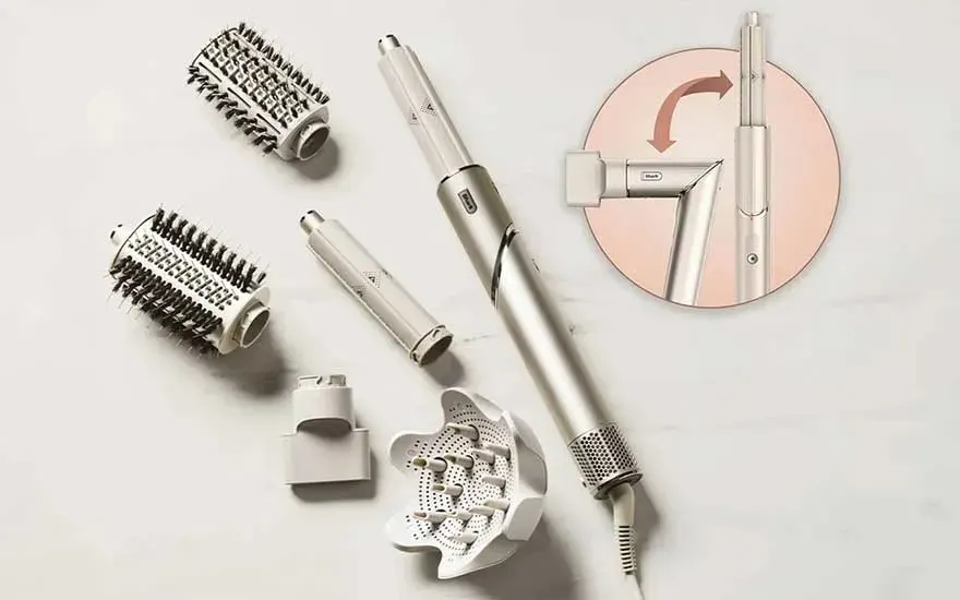 Sèche-cheveux argenté avec divers accessoires, y compris des brosses et un diffuseur, sur un fond blanc. Diagramme d'angle inclus.