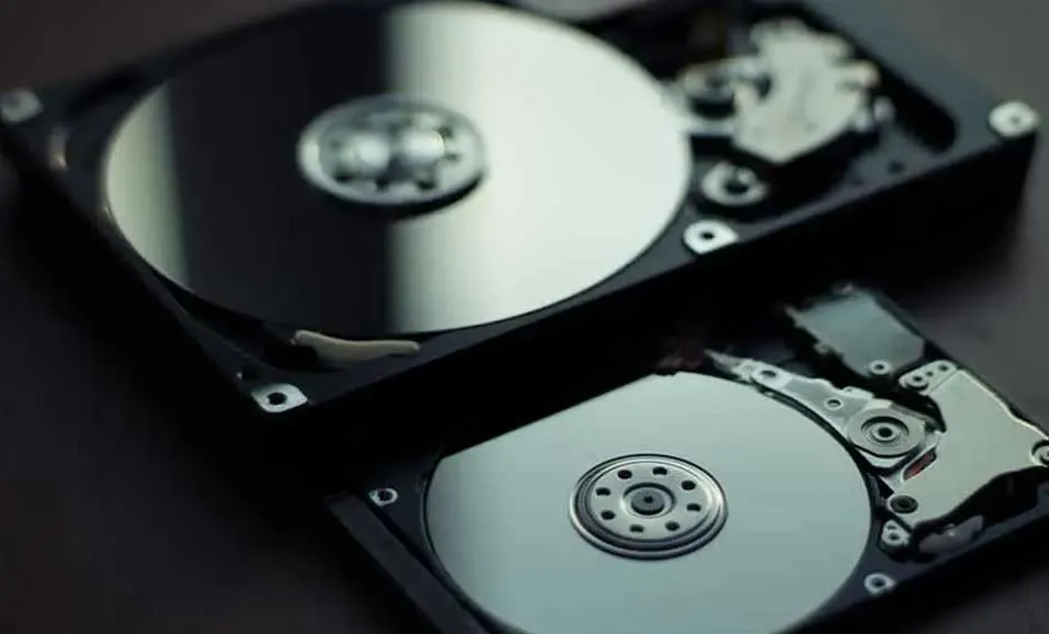 Twee open harde schijven liggen op elkaar. De schijven zijn zilverkleurig en de behuizing is zwart.