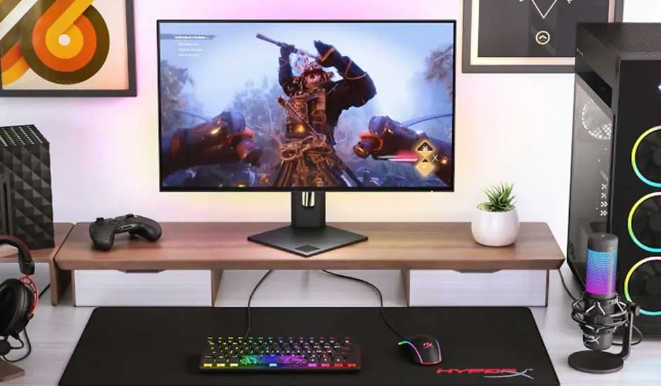 Bureau de jeu avec écran affichant un jeu vidéo, clavier multicolore, souris et casque audio. Boîtier PC éclairé à droite.