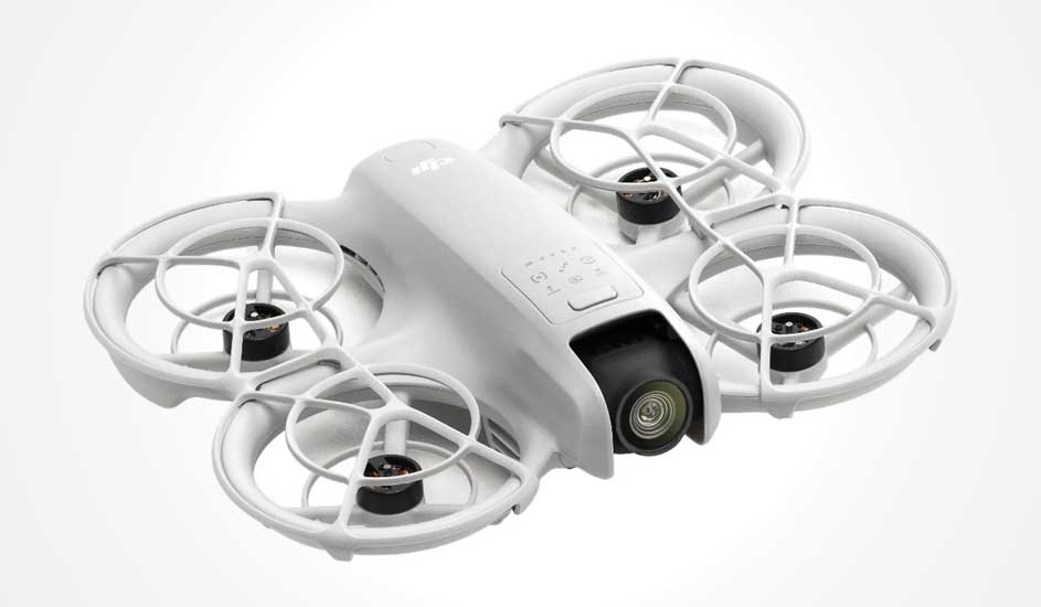 Dit is een witte DJI drone met vier propellers, beschermende ringen en een camera aan de voorkant, ontworpen voor veilig gebruik binnenshuis.