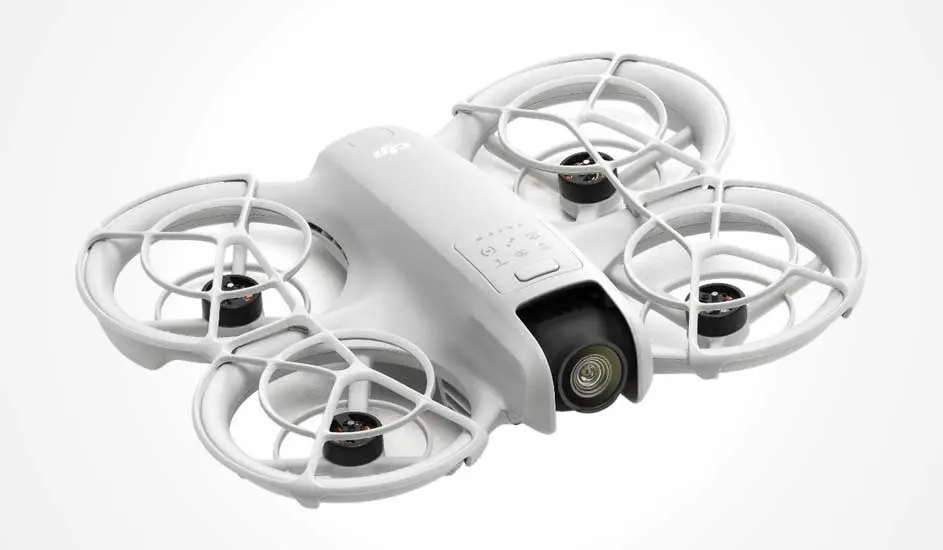 Dit is een witte DJI drone met vier propellers, beschermende ringen en een camera aan de voorkant, ontworpen voor veilig gebruik binnenshuis.
