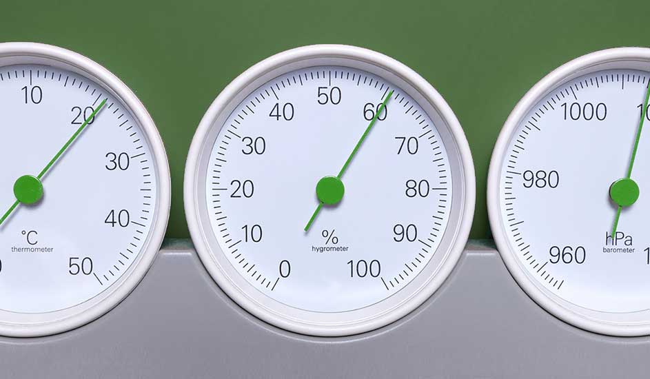 Trois cadrans blancs avec des aiguilles vertes indiquent la température, l'humidité et la pression sur un fond vert.