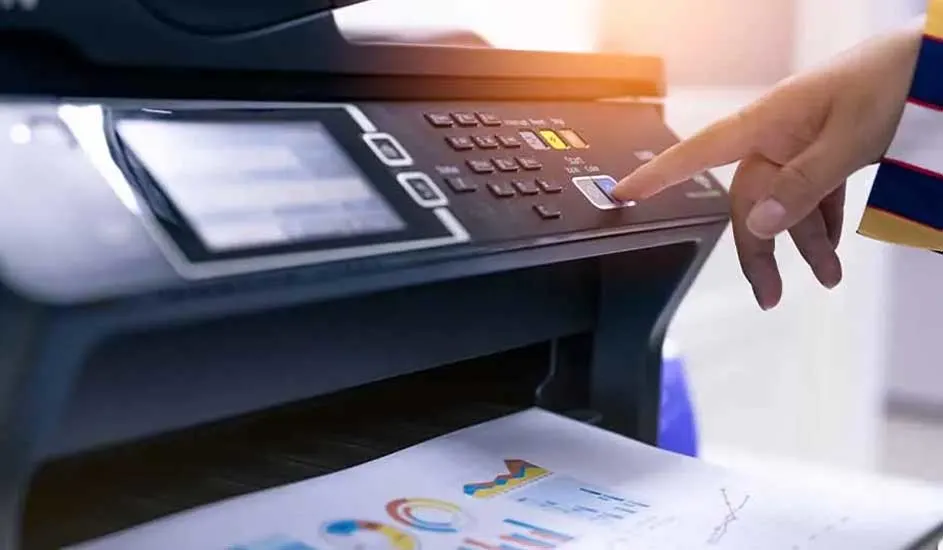 Een zwarte printer met een scherm en knoppen, een hand drukt op de startknop, papier met grafieken komt eruit.