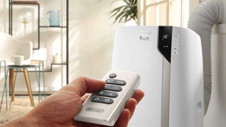 Un climatiseur blanc De'Longhi est contrôlé par une télécommande blanche. Un tuyau d'évacuation est visible.