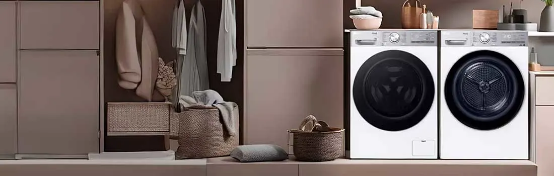 Moderne wasruimte met wasmachine en droger, zachte roze kasten, open garderobe, manden, handdoeken en groene planten.