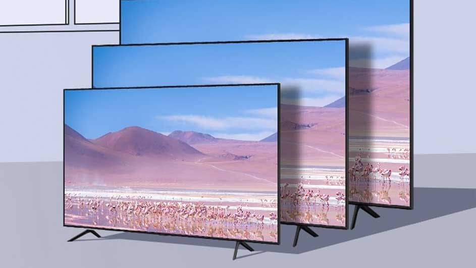 Trois téléviseurs noirs affichent un paysage désertique avec des montagnes violettes et un ciel bleu.