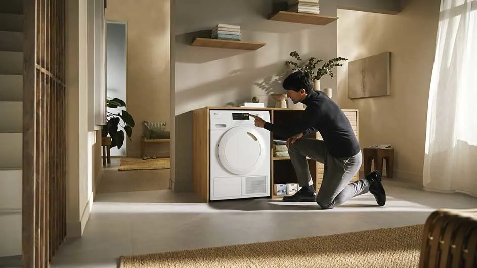 Intérieur avec séchoir blanc intégré dans une unité en bois clair. Étagères murales et tapis texturé.