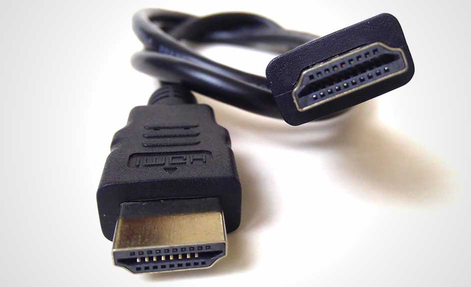 Un câble HDMI noir avec deux connecteurs métalliques dorés est posé sur une surface blanche.