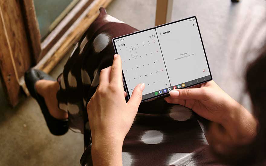 Une personne utilise un Galaxy Z Fold8 déplié sur ses genoux, avec calendrier et notes visibles dans un moment calme.
