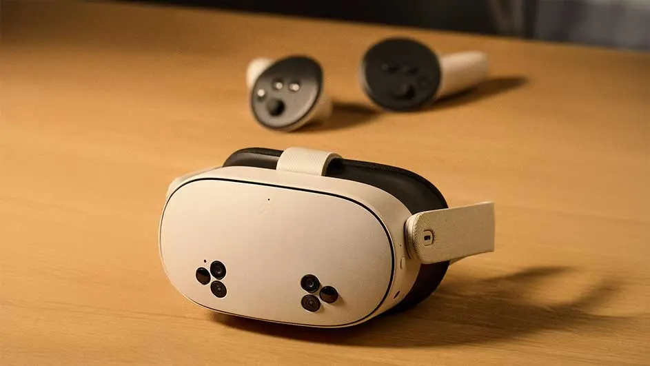 Witte VR-bril en twee controllers op een houten tafel. De bril heeft zwarte sensoren en een verstelbare band.