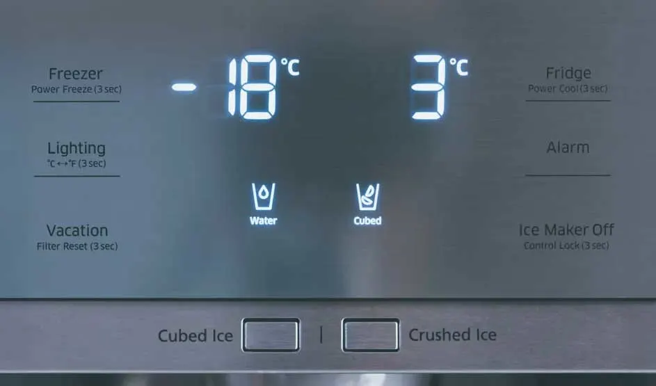 Écran de réfrigérateur gris avec affichage numérique : congélateur à -18°C, réfrigérateur à 3°C, options eau et glaçons.